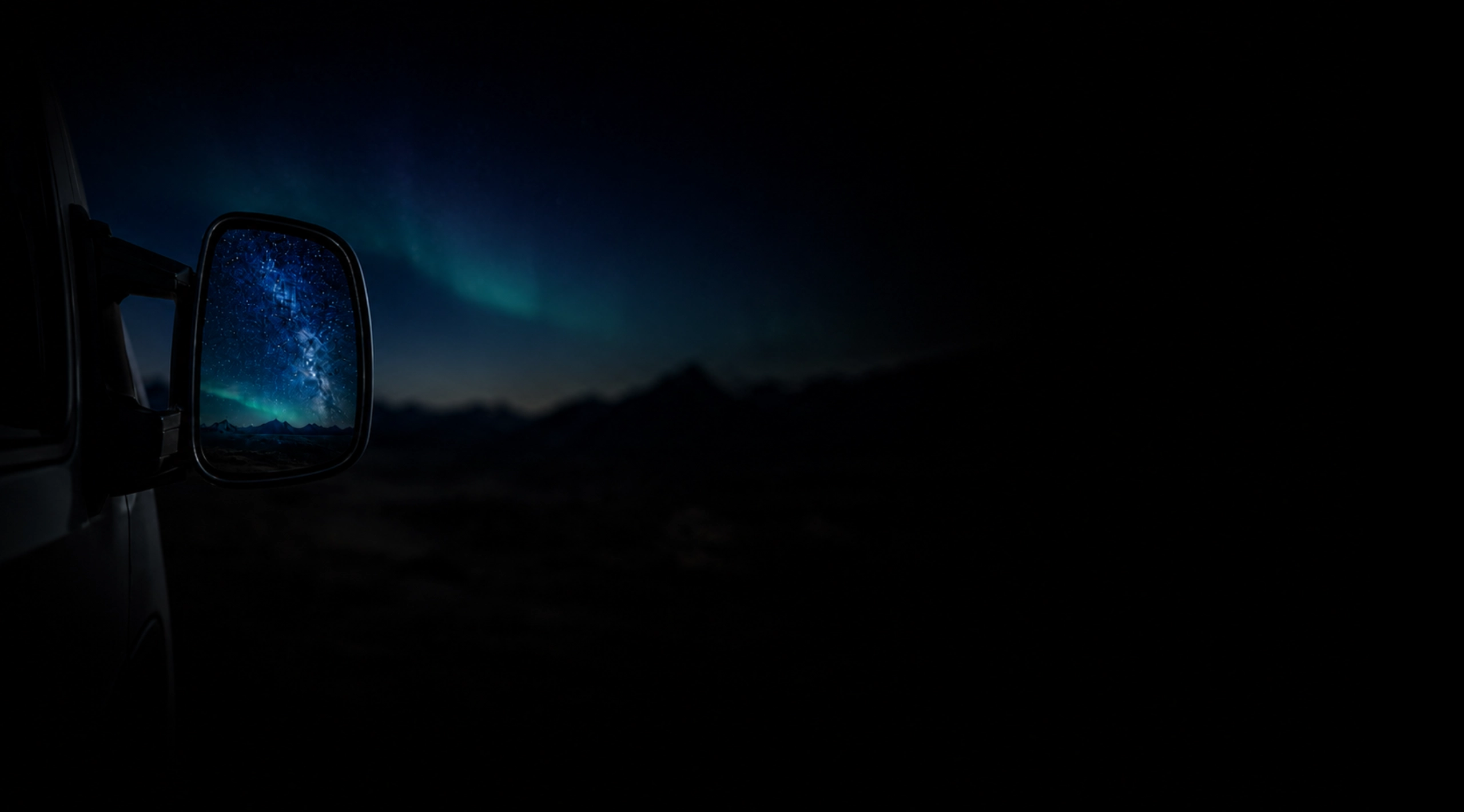 Wohnmobil bei Nacht vor Bergpanorama mit Polarlicht